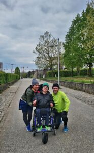 Photo of three people on a run, with one in a wheelchair